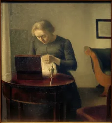 Mujer del artista en la mesa de costura